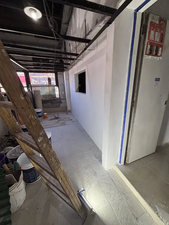 Local en obra con una pared nueva de placa de yeso